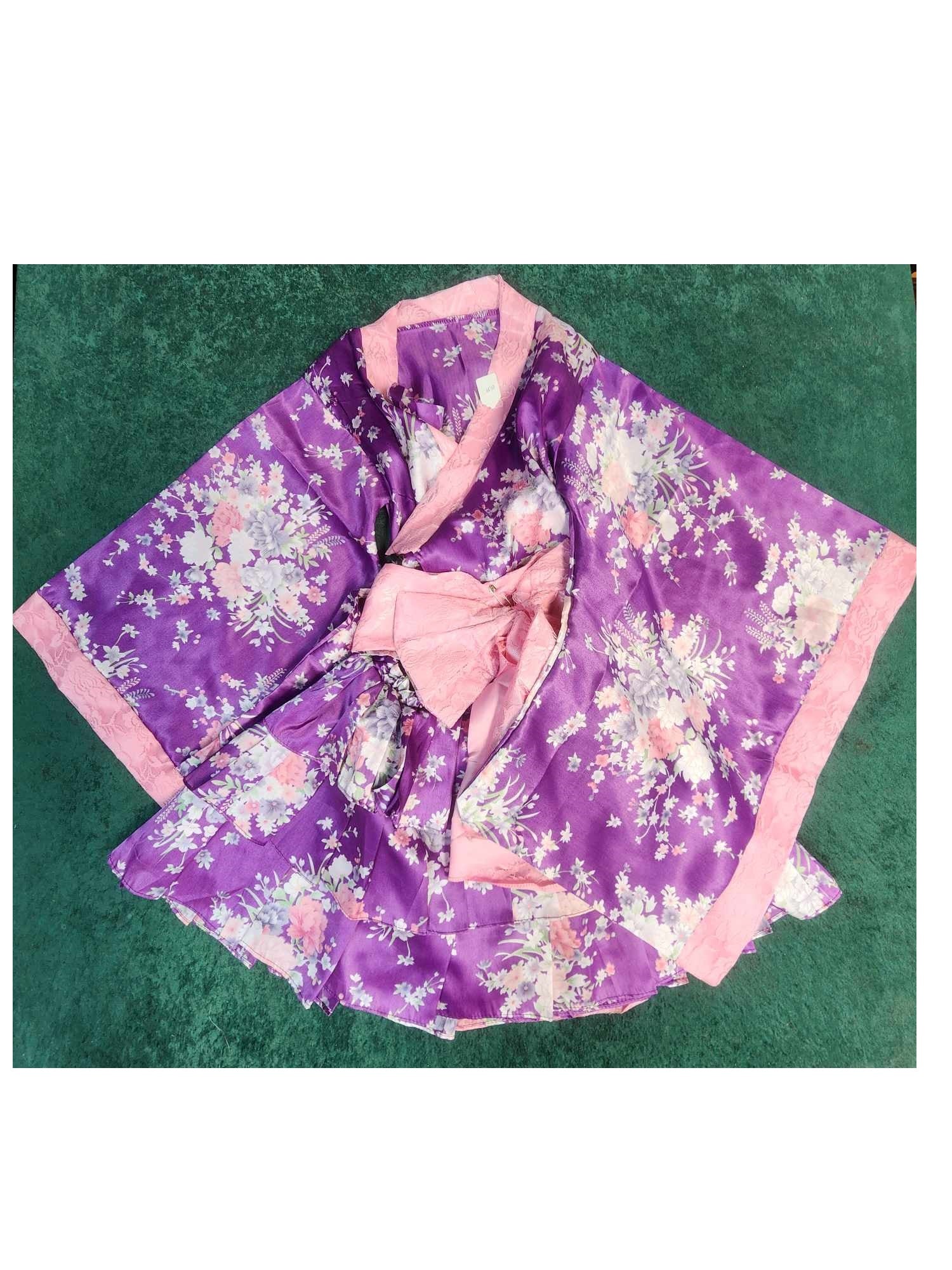 Purple kimono with pink lining that has a white, pink, and red flower print. A pink bow wraps the whole kimono together.